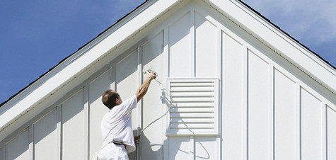 Painter applying an exterior house finish